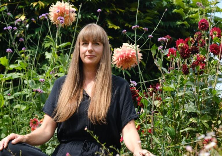 Image of Jemma Foster sat amongst plants and flowers.