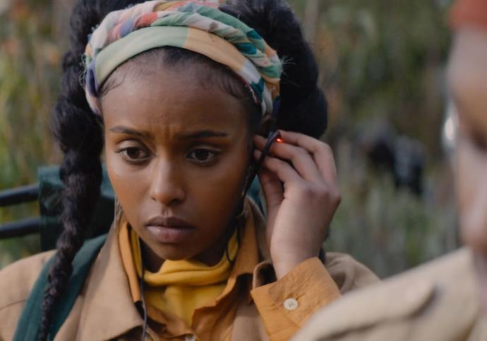 black girl with a white headband, looking sad. 