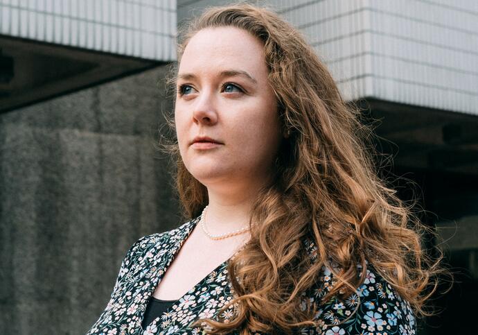 Person with long brown hair looking into distance