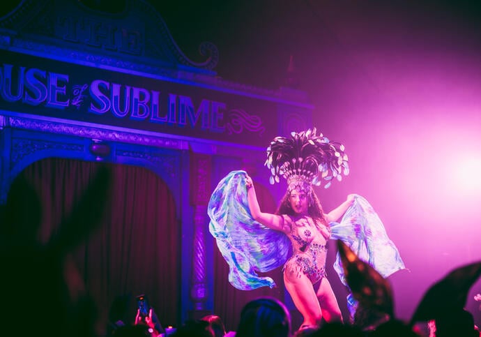 A person performs on stage in a cabaret setting