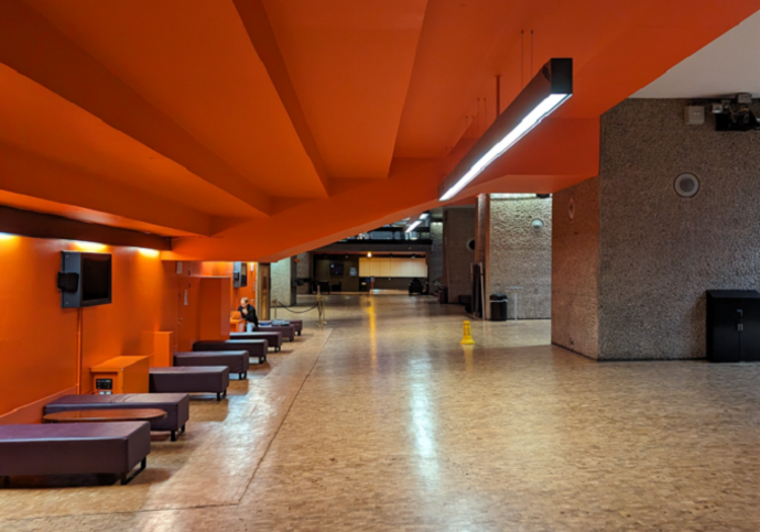 Generic brown benches line the wall of the Hall