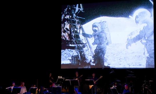 Icebreaker performing in front of footage from the Apollo moon landing