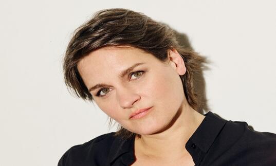Madeline Peyroux, wearing black, looking into the camera 