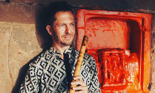 Jason Kalidas holding a bansuri