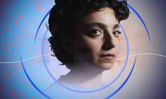 A headshot of Shiva Feshareki, with circular blue swirls around her. In the background is an abstract, blue, web-like pattern and some wavy shapes suggestive of sound waves.