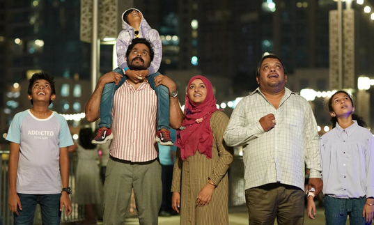 A family stand in a city look forward at the view. 