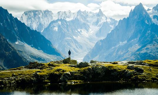 A man looking out at a vast mountainous landscape