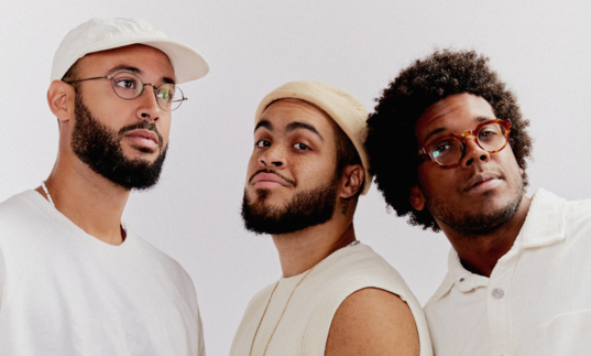 Three black men. members of Gilsons, dressed in white 