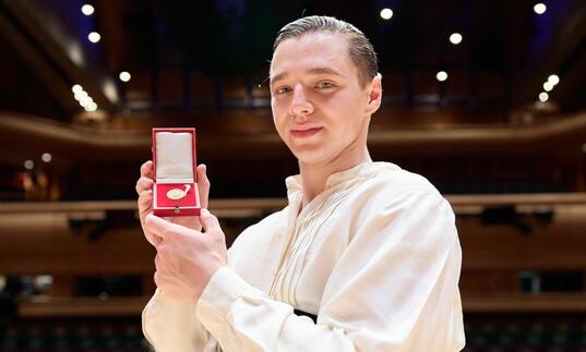 Double Bassist Strahinja Mitrović pictured in Barbican Hall, holding up the Gold Medal in box