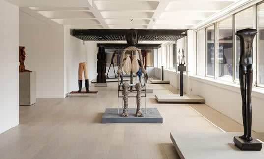 A shot of the gallery, showing sculptures by Giacometti and Huma Bhabha.