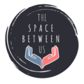 the space between us logo with 2 hands left hand in blue and right hand in pink
